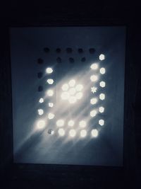 Illuminated lights seen through window at night