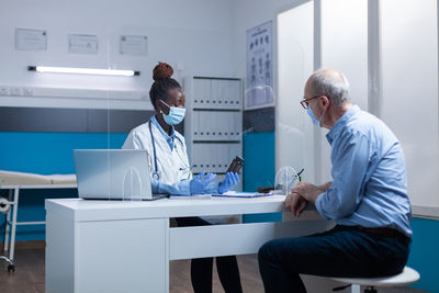 Doctor holding bottle discussing with patient