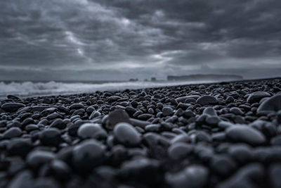 Surface level of stones on beach against sky