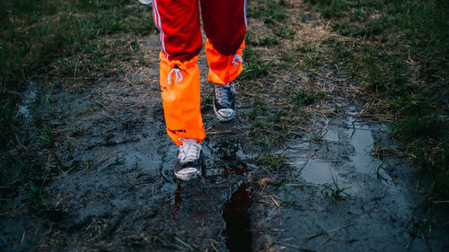 Low section of person standing on wet land