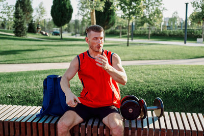 Portrait of smiling young woman exercising in park