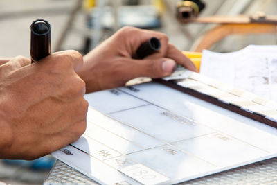 Close-up of man working on clapper board