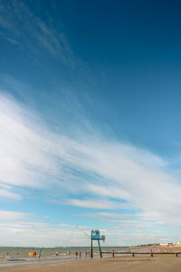 Scenic view of beach with blue fishing hut against blue sky