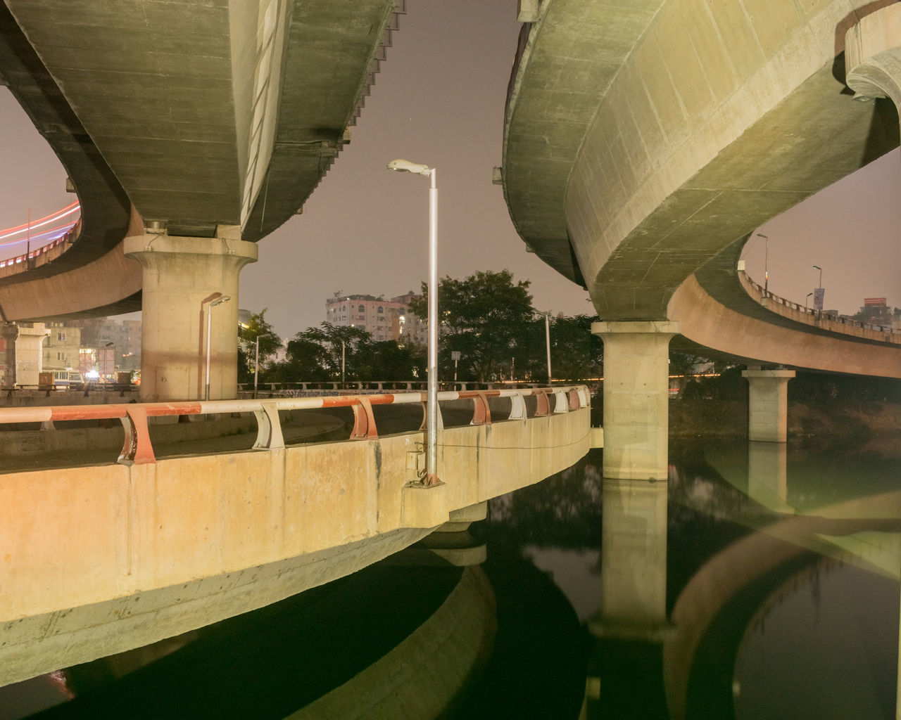 BRIDGE OVER ROAD BY BUILDINGS IN CITY