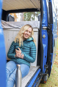 Portrait of a smiling young woman sitting in car