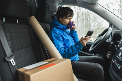 Man using mobile phone while sitting in car