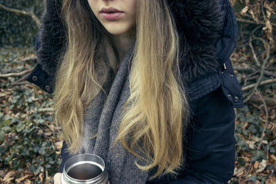 Midsection of woman having drink during winter