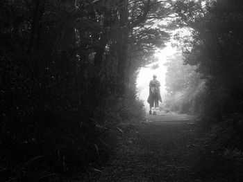 Rear view of woman walking in forest