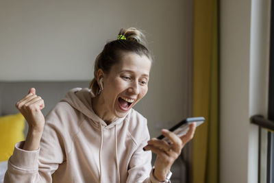 Young woman using mobile phone at home