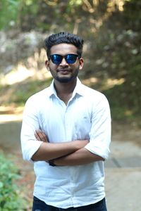 Portrait of young man wearing sunglasses standing outdoors