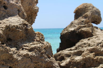 Rock formation on beach against sky