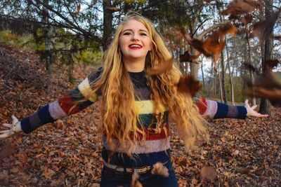 Portrait of young woman standing in forest during winter