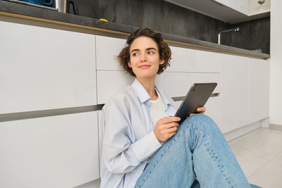 Portrait of young woman using digital tablet