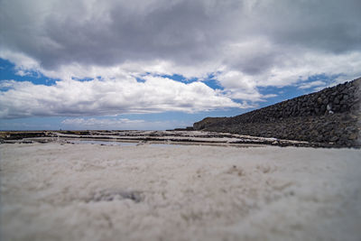 Surface level of sandy beach against sky