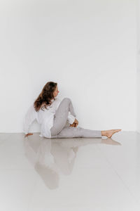 Girl sitting on the floor on a white background