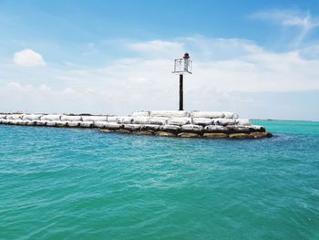 Lighthouse by sea against sky