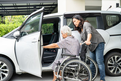 Help and support asian senior  woman patient prepare get to her car.