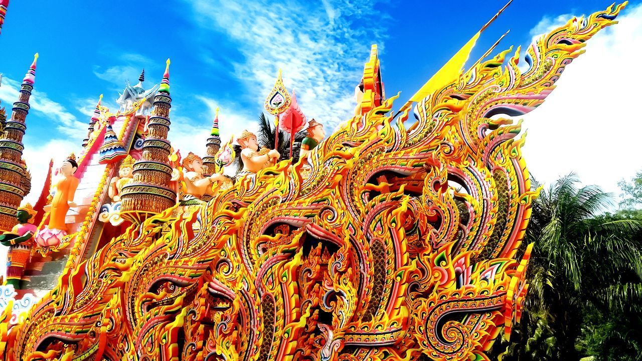 LOW ANGLE VIEW OF GOLD COLORED SCULPTURE AGAINST SKY