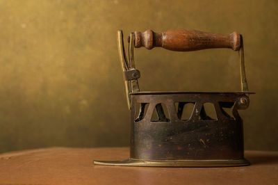 Close-up of old metal on table against wall at home