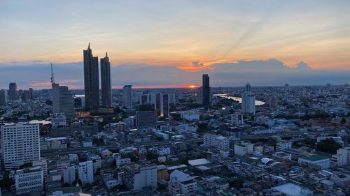 Aerial view of modern buildings against sky during sunset