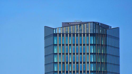 Low angle view of modern building against clear blue sky