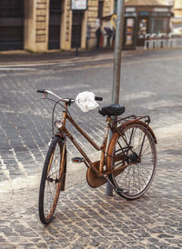 Bicycle parked on street against buildings