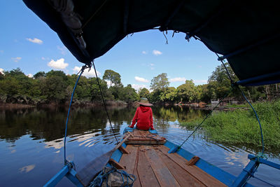Rear view of man on boat against sky