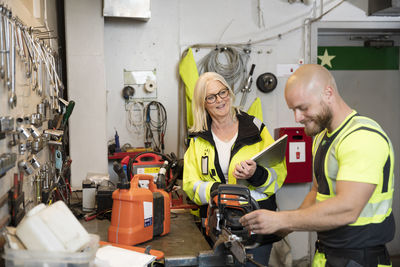 Male and female colleagues working in workshop