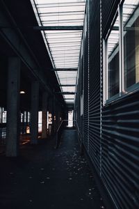 Covered walkway amidst bridge and building