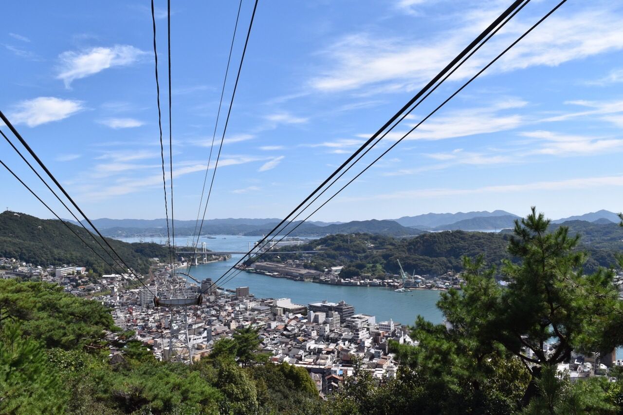 sky, connection, mountain, power line, cloud - sky, water, transportation, cable, cloud, tree, electricity pylon, blue, river, electricity, scenics, tranquil scene, mountain range, tranquility, sea, day