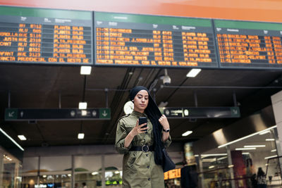 Portrait of modern muslim woman using her smartphone on a train station