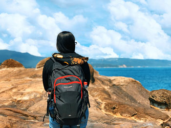 Rear view of man looking at sea against sky