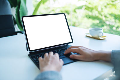 Midsection of woman using laptop on table