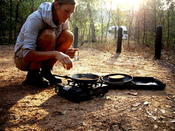 Full length of woman making breakfast at campsite