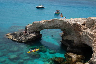 High angle view of people on rock by sea