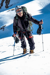 Portrait of a mountaineer on a snowy mountain looking at camera