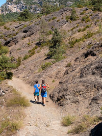 Rear view of people walking on terrain