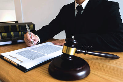 Midsection of judge working at desk in office