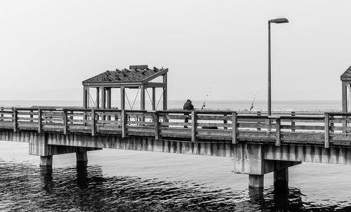 Pier on sea against clear sky