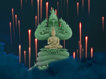 Statue against illuminated temple