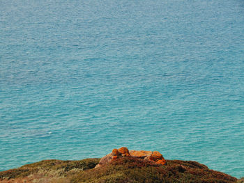 Scenic view of sea and orange rocks