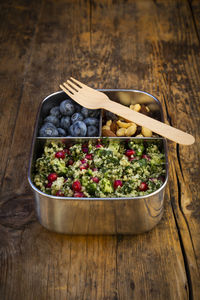 Lunchbox with bulgur herbs salad with pomegranate seeds, taboule, blueberries and trail mix