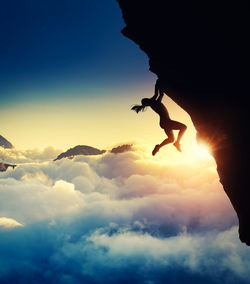 Silhouette man on rock against sky during sunset