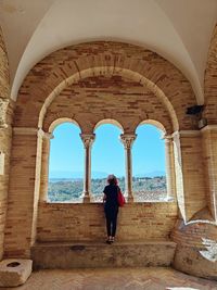 Rear view of man walking in tunnel