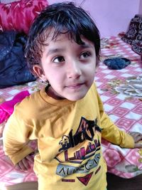 Portrait of cute boy on bed at home