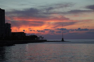 View of sailboat in sea against cloudy sky