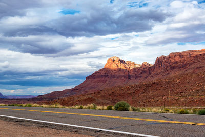 Country road passing through grand canyon national park against cloudy sky