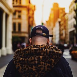 Rear view of man standing on street in city