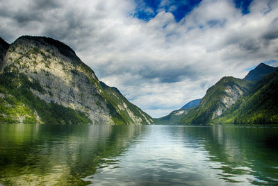 Scenic view of lake by mountains against sky