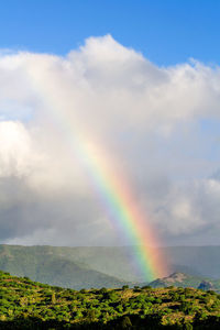 Scenic view of rainbow over landscape against sky